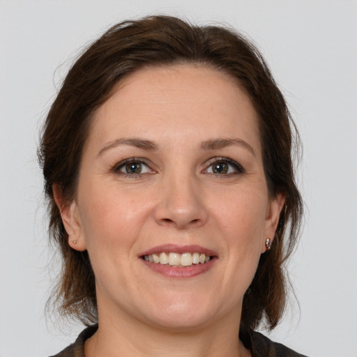 Joyful white adult female with medium  brown hair and grey eyes