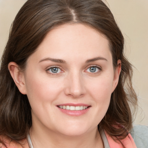 Joyful white young-adult female with medium  brown hair and blue eyes