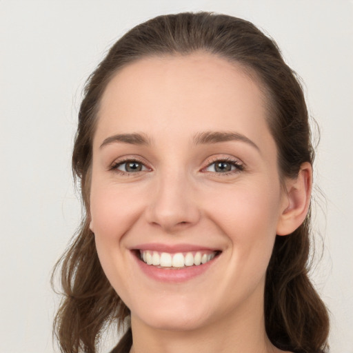 Joyful white young-adult female with long  brown hair and grey eyes