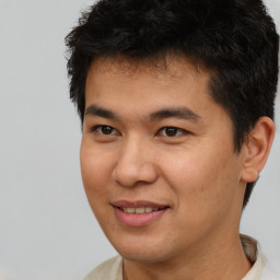 Joyful asian young-adult male with short  brown hair and brown eyes