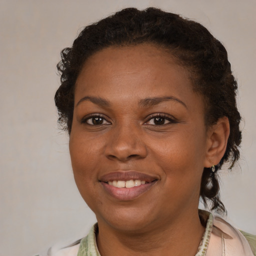 Joyful black young-adult female with short  brown hair and brown eyes