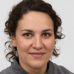 Joyful white adult female with medium  brown hair and brown eyes