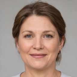 Joyful white adult female with medium  brown hair and grey eyes