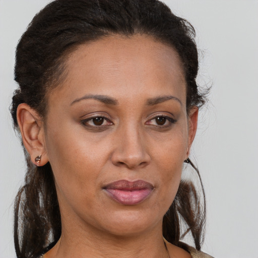 Joyful black adult female with long  brown hair and brown eyes