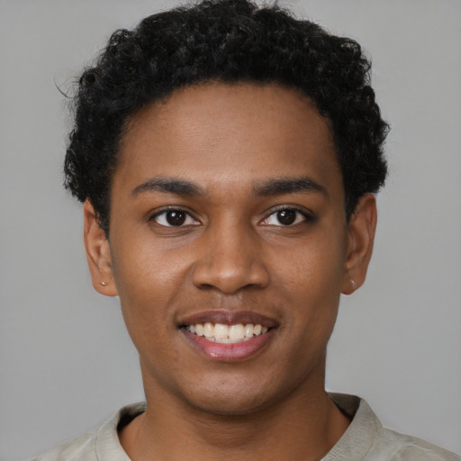 Joyful black young-adult male with short  brown hair and brown eyes