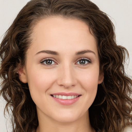 Joyful white young-adult female with long  brown hair and green eyes