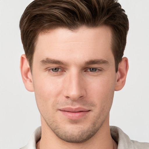 Joyful white young-adult male with short  brown hair and grey eyes