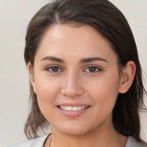 Joyful white young-adult female with medium  brown hair and brown eyes