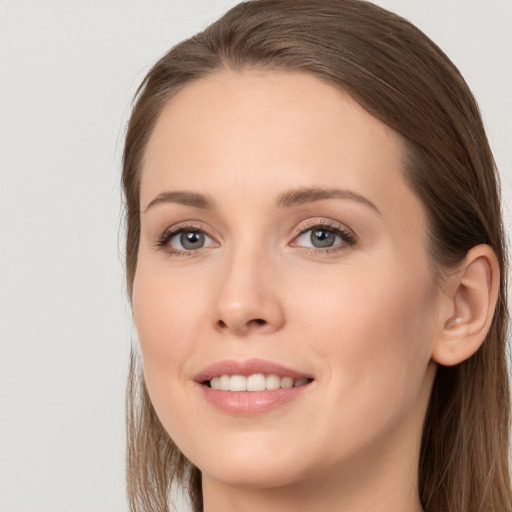 Joyful white young-adult female with long  brown hair and grey eyes