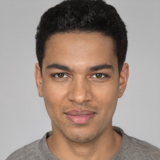Joyful black young-adult male with short  black hair and brown eyes
