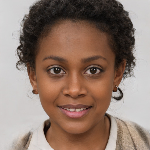 Joyful black child female with short  brown hair and brown eyes