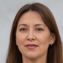 Joyful white adult female with long  brown hair and brown eyes