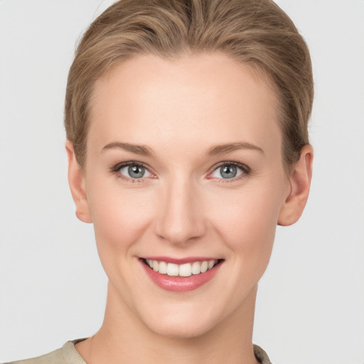 Joyful white young-adult female with short  brown hair and grey eyes