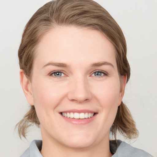 Joyful white young-adult female with medium  brown hair and blue eyes