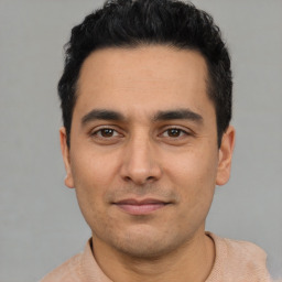 Joyful latino young-adult male with short  black hair and brown eyes