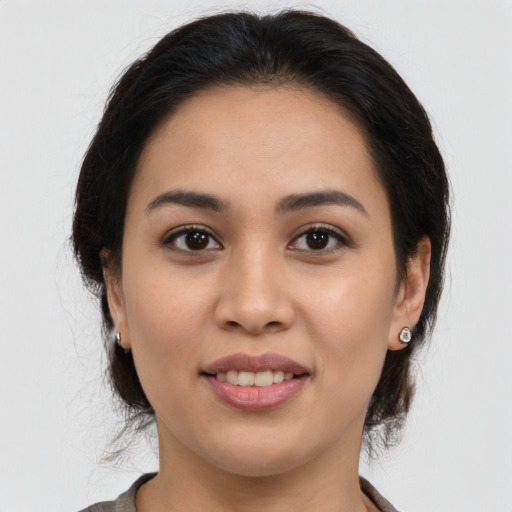 Joyful latino young-adult female with medium  brown hair and brown eyes