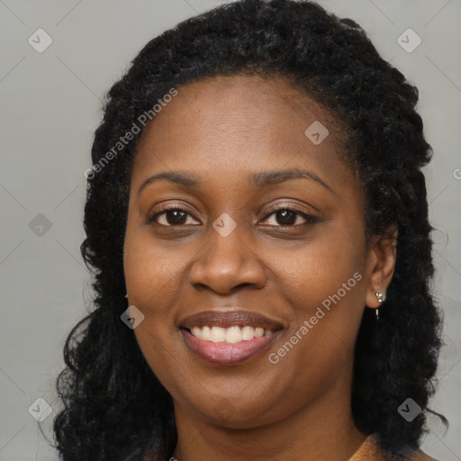 Joyful black young-adult female with long  brown hair and brown eyes