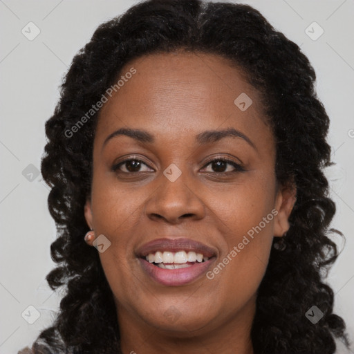 Joyful black adult female with long  brown hair and brown eyes