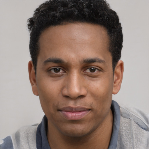 Joyful black young-adult male with short  brown hair and brown eyes