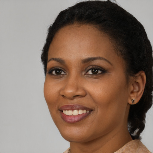 Joyful black young-adult female with short  black hair and brown eyes