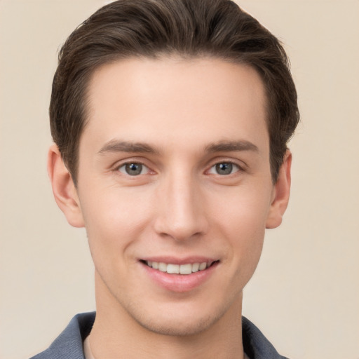 Joyful white young-adult male with short  brown hair and grey eyes