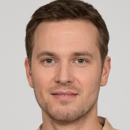 Joyful white young-adult male with short  brown hair and grey eyes