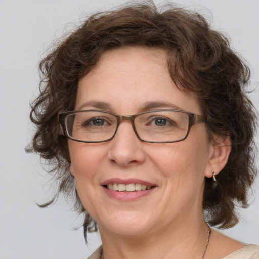 Joyful white middle-aged female with medium  brown hair and blue eyes