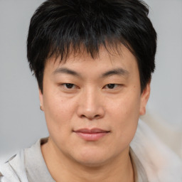 Joyful asian young-adult male with short  brown hair and brown eyes