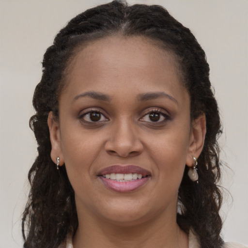 Joyful black young-adult female with long  brown hair and brown eyes