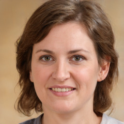 Joyful white young-adult female with medium  brown hair and green eyes