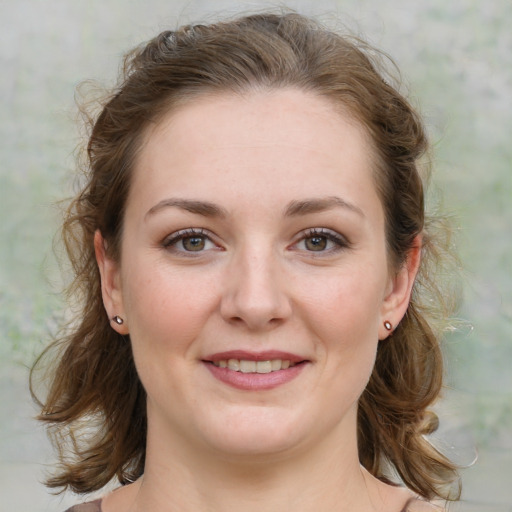 Joyful white young-adult female with medium  brown hair and green eyes