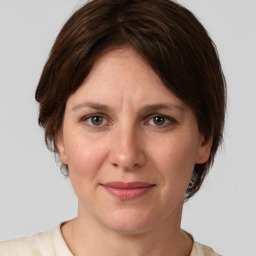 Joyful white adult female with medium  brown hair and grey eyes