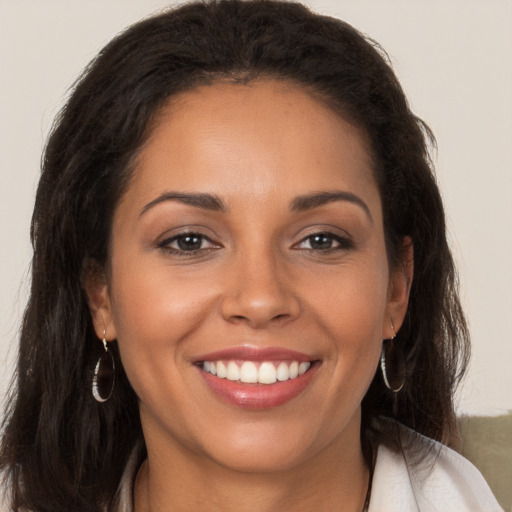 Joyful latino young-adult female with long  brown hair and brown eyes