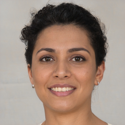 Joyful latino young-adult female with short  brown hair and brown eyes