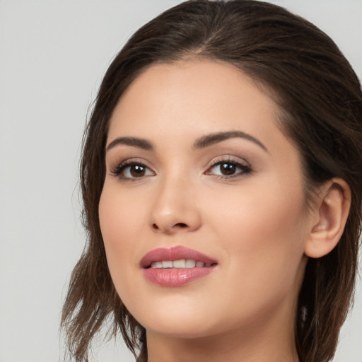 Joyful white young-adult female with long  brown hair and brown eyes