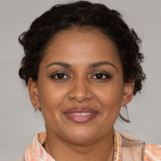Joyful black adult female with medium  brown hair and brown eyes