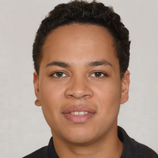 Joyful black young-adult male with short  brown hair and brown eyes