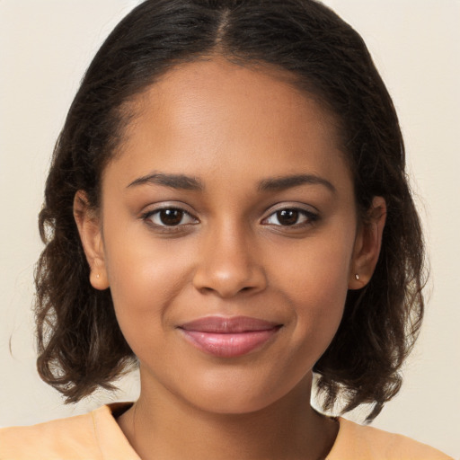 Joyful black young-adult female with medium  brown hair and brown eyes