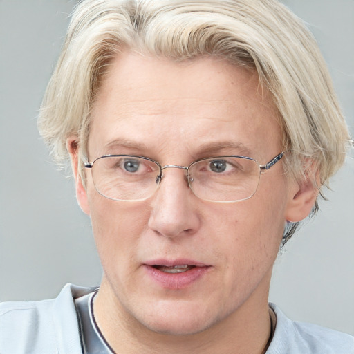 Joyful white middle-aged male with short  blond hair and blue eyes