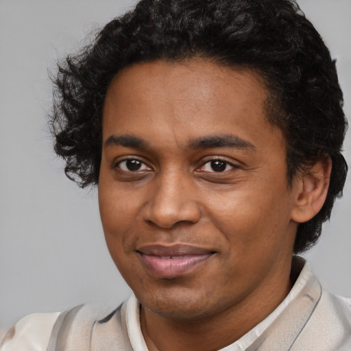 Joyful black young-adult male with short  brown hair and brown eyes