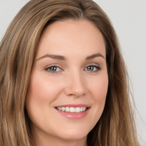 Joyful white young-adult female with long  brown hair and brown eyes