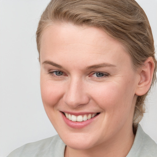 Joyful white young-adult female with medium  brown hair and blue eyes