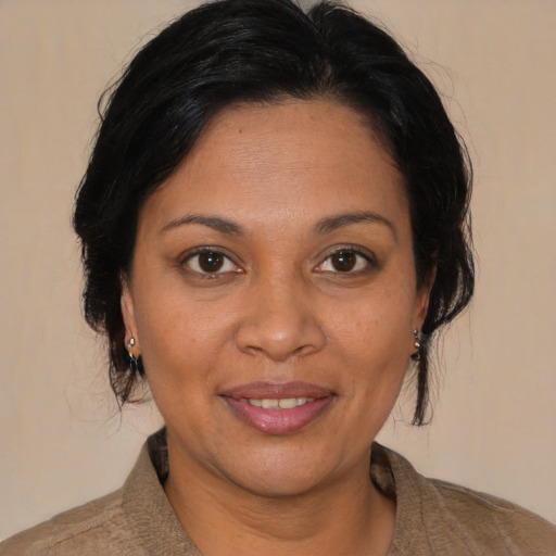 Joyful latino adult female with medium  brown hair and brown eyes