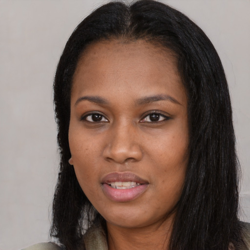 Joyful black young-adult female with long  black hair and brown eyes