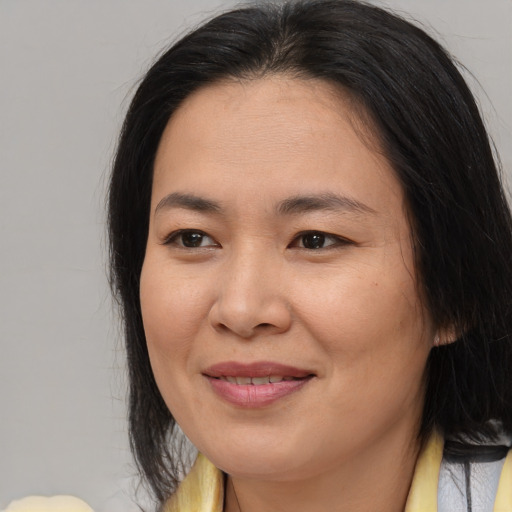 Joyful asian adult female with medium  brown hair and brown eyes