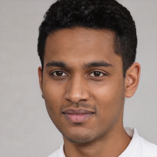 Joyful black young-adult male with short  black hair and brown eyes