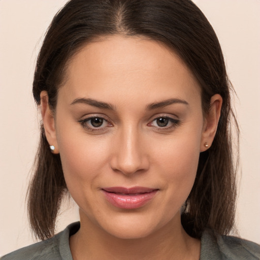 Joyful white young-adult female with long  brown hair and brown eyes