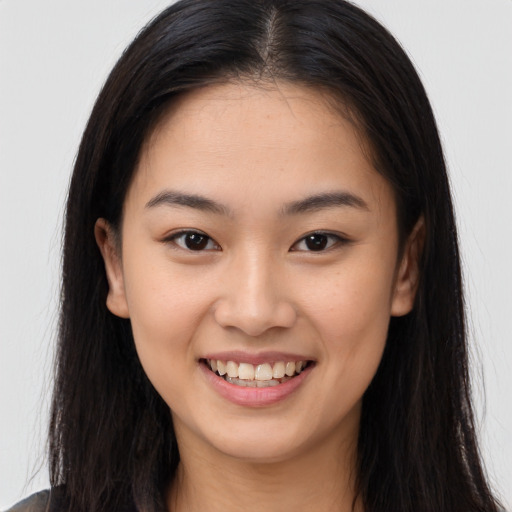 Joyful asian young-adult female with long  brown hair and brown eyes