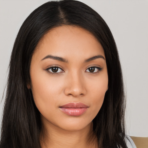 Joyful latino young-adult female with long  brown hair and brown eyes