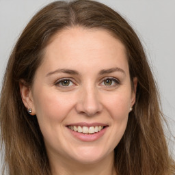 Joyful white young-adult female with long  brown hair and grey eyes